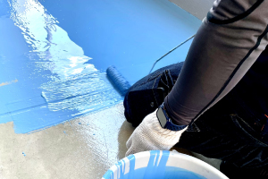 床を塗装する作業員